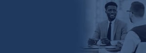 2 colleagues sitting at a table with a navy color overlay